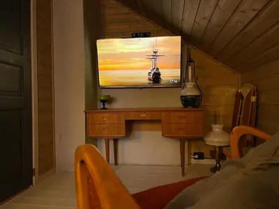 a living room with a tv on the wall at Tronstadbu- 1800s Cabin near Geirangerfjord & Slogen Hike in Hellesylt