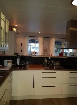 a kitchen with white cabinets and black counter tops at Rorbu i Austevoll med 3 soverom og mulighet for båtleie in Kolbeinsvik