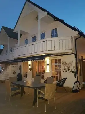 a table and chairs in front of a house at Rorbu i Austevoll med 3 soverom og mulighet for båtleie in Kolbeinsvik