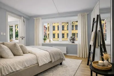 a bedroom with a large bed and windows at Modern apartment in the heart of Bergen in Bergen