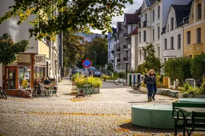 a woman walking down a street in a city at Modern apartment in the heart of Bergen in Bergen