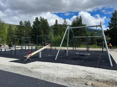 an empty playground with a slide and swings at Hyt leilighet med 2 soverom in Bjorli