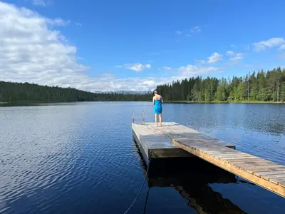 a woman standing on a dock on a lake at Sveheim - cabin with an amazing view in Flå