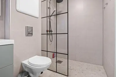 a bathroom with a toilet and a shower at Elegant Urban Apartment in Bergen
