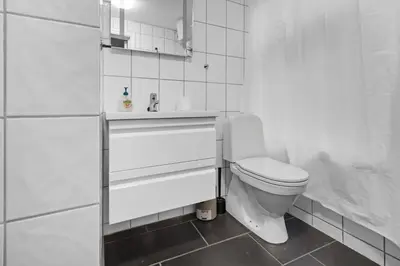 a white bathroom with a toilet and a sink at Peaceful Urban Residence in Bergen