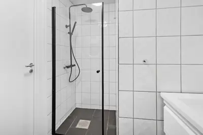 a shower with a glass door in a bathroom at Peaceful Urban Residence in Bergen