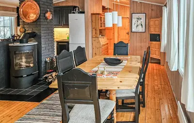 a dining room with a wooden table and a fireplace at 3 Bedroom Stunning Home In Uvdal in Uvdal
