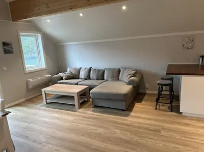 a living room with a couch and a table at Rorbu i Gilsvågen - 3 soverom - Båtutleie in Austevoll