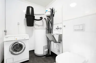 a bathroom with a washing machine and a sink at Rorbu i Gilsvågen - 3 soverom - Båtutleie in Austevoll