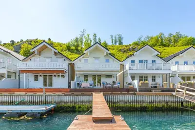 a large house on the water with a dock at Rorbu i Gilsvågen - 3 soverom - Båtutleie in Austevoll