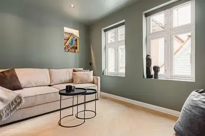 a living room with a couch and a table at Bryggen // Fløyen Apartments in Bergen