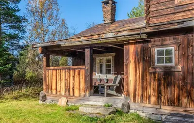 a wooden cabin with a table and a chair outside at Nice Home In Bjorli With Wifi in Bjorli