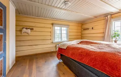 a bedroom with a bed in a room with wooden walls at Nice Home In Bjorli With Wifi in Bjorli