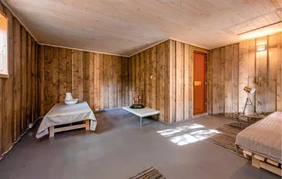 a room with wooden walls and a bed and a table at Nice Home In Bjorli With Wifi in Bjorli