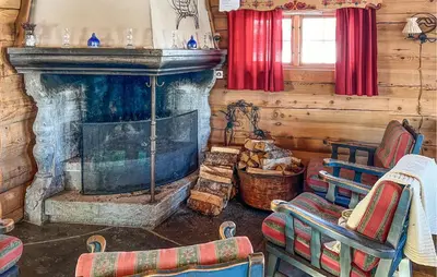 a living room with a fireplace in a log cabin at 6 Bedroom Cozy Home In Kvam in Kvam