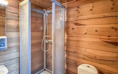 a shower in a bathroom with wooden walls at 6 Bedroom Cozy Home In Kvam in Kvam