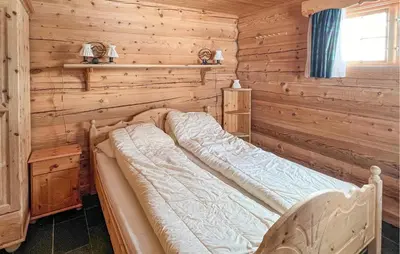 a bedroom with a bed in a log cabin at 6 Bedroom Cozy Home In Kvam in Kvam