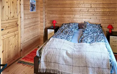 a bed in a room with a wooden wall at 4 Bedroom Pet Friendly Home In Tydal in Tydal