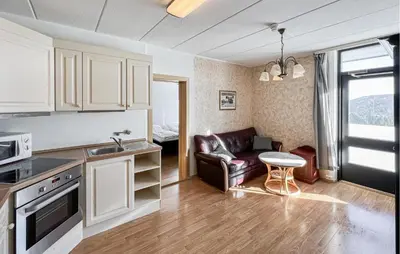 a kitchen and living room with a couch and a table at Gorgeous Apartment In Kvam With Sauna in Kvam