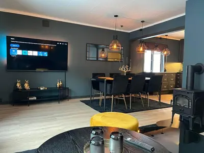 a living room with a table and chairs and a television at Rjukan Sentrum Apartments NO 1 in Rjukan