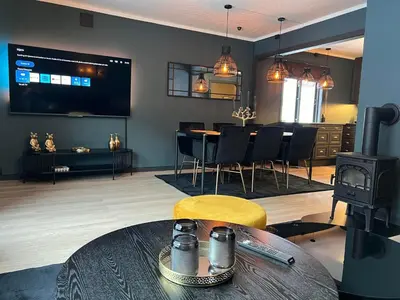 a living room with a table and a stove at Rjukan Sentrum Apartments NO 1 in Rjukan