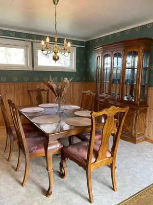 a dining room with a wooden table and chairs at Honey bay cottage in Stadlandet