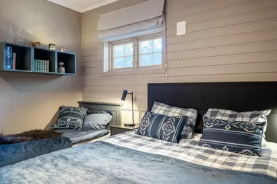 a bedroom with a bed with blue and white pillows at Beitostølen! Midt i sentrum! Ski in ski out! Badstue-Massasjedusj-Steamdusj in Beitostøl