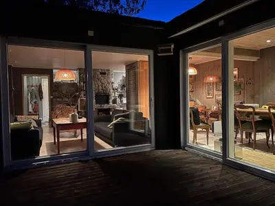 a living room and dining room with sliding glass doors at Cabin by the Fjord in Øksendalsøra