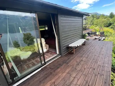 a large deck with a view of the backyard at Cabin by the Fjord in Øksendalsøra