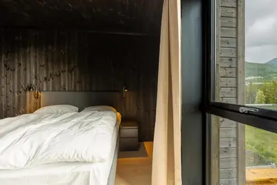 a bedroom with a bed and a large window at Vister, Hemsedal - fine leiligheter rett ved Fyri Resort - Ski inn - Ski out in Hemsedal