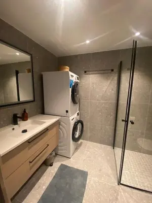 a bathroom with a shower and a sink and a refrigerator at Vister, Hemsedal - fine leiligheter rett ved Fyri Resort - Ski inn - Ski out in Hemsedal