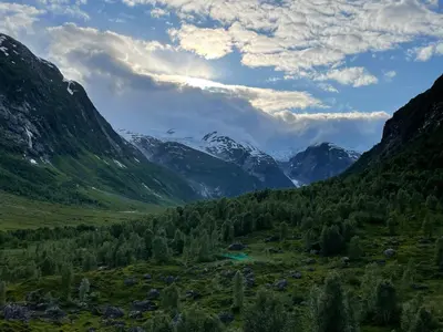 a valley in the mountains with a river and trees at Tungestølen in Veitastrond