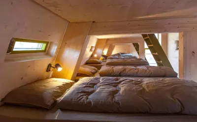 a row of beds in a room with stairs at Tungestølen in Veitastrond