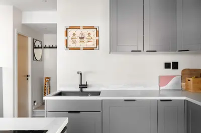 a kitchen with white cabinets and a sink at Nordnes - Amazing view of Bryggen! in Bergen