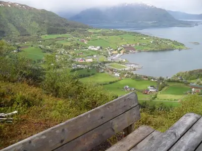 a bench sitting on top of a hill overlooking a body of water at Orset setra - back to basic cabin - with amazing view in Torvikbukt