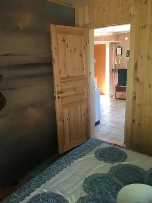 a bedroom with a door and a bed in a room at Rønlund Hyttepark, Midgard in Ron
