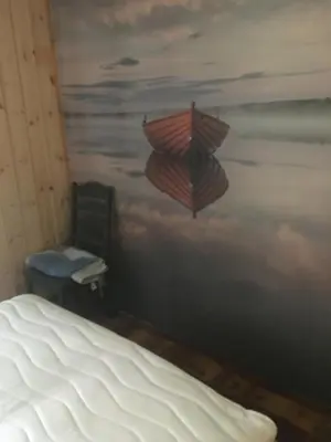 a bedroom with a bed and a painting of an umbrella at Rønlund Hyttepark, Midgard in Ron