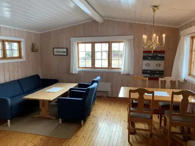 a living room with a table and a blue couch at Tyinholmen Høyfjellsstuer in Eidsbugarden
