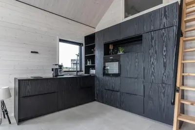 a kitchen with black cabinets and a counter at Brattøya sjøstuer in Kristiansund