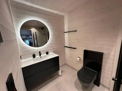a bathroom with a sink and a toilet and a mirror at Brattøya sjøstuer in Kristiansund