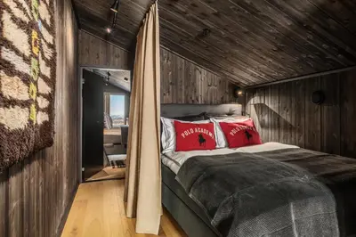 a bedroom with a bed with red pillows at Kikut Alpin Lodge 2302 in Geilo