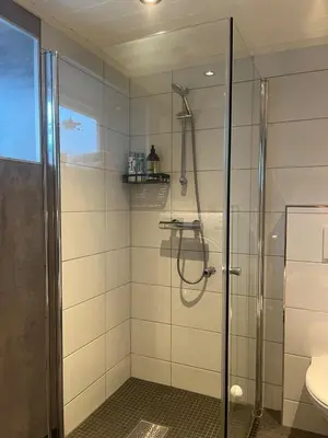 a shower with a glass door in a bathroom at Cozy basement apartment in Orkanger in Orkanger