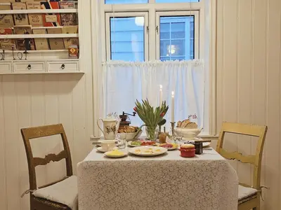 a dining room table with a white table cloth and candles at Unikt og romslig hus perfekt for grupper in Nordfjordeid