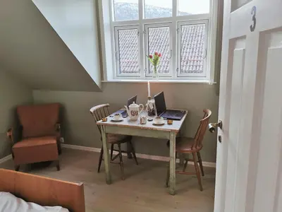 a room with a table with a laptop and chairs at Unikt og romslig hus perfekt for grupper in Nordfjordeid