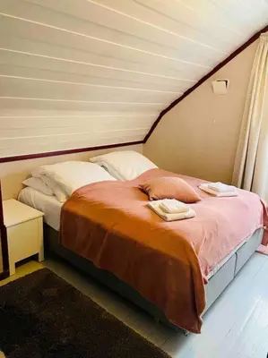 a bedroom with a bed with two towels on it at Solrikt og sentralt. Ta med både to og firbeinte in Lillehammer