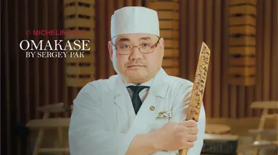 a man in a chefs hat holding a knife at Skostredet Hotel & Spa in Bergen