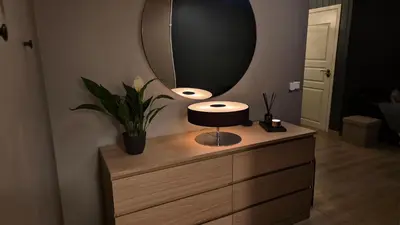 a dresser with a mirror and a lamp on it at Moderne cityleilighet Sogndal in Sogndal