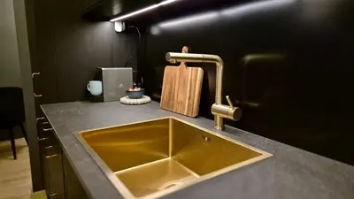a bathroom with a sink and a black wall at Moderne cityleilighet Sogndal in Sogndal