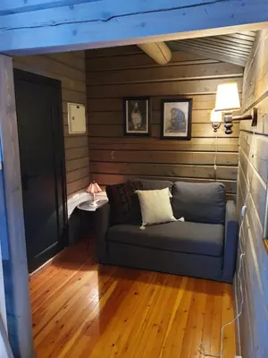 a living room with a couch in a room with wooden walls at Bjørgebu Camping AS in Mysusæter