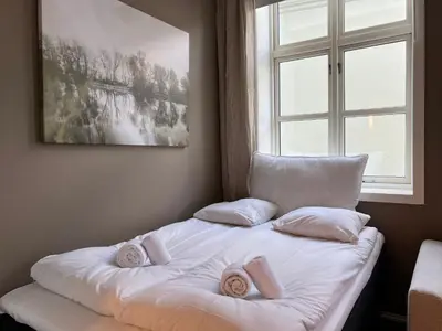 a bed with two pillows on it in front of a window at Vaskerelven 4 in Bergen